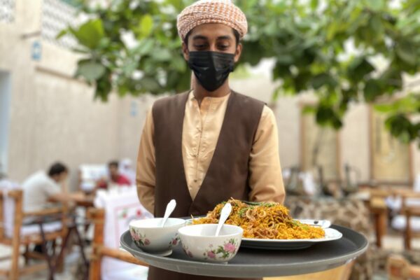 Server with Emirati Lamb Machboos at a traditional restaurant (1)